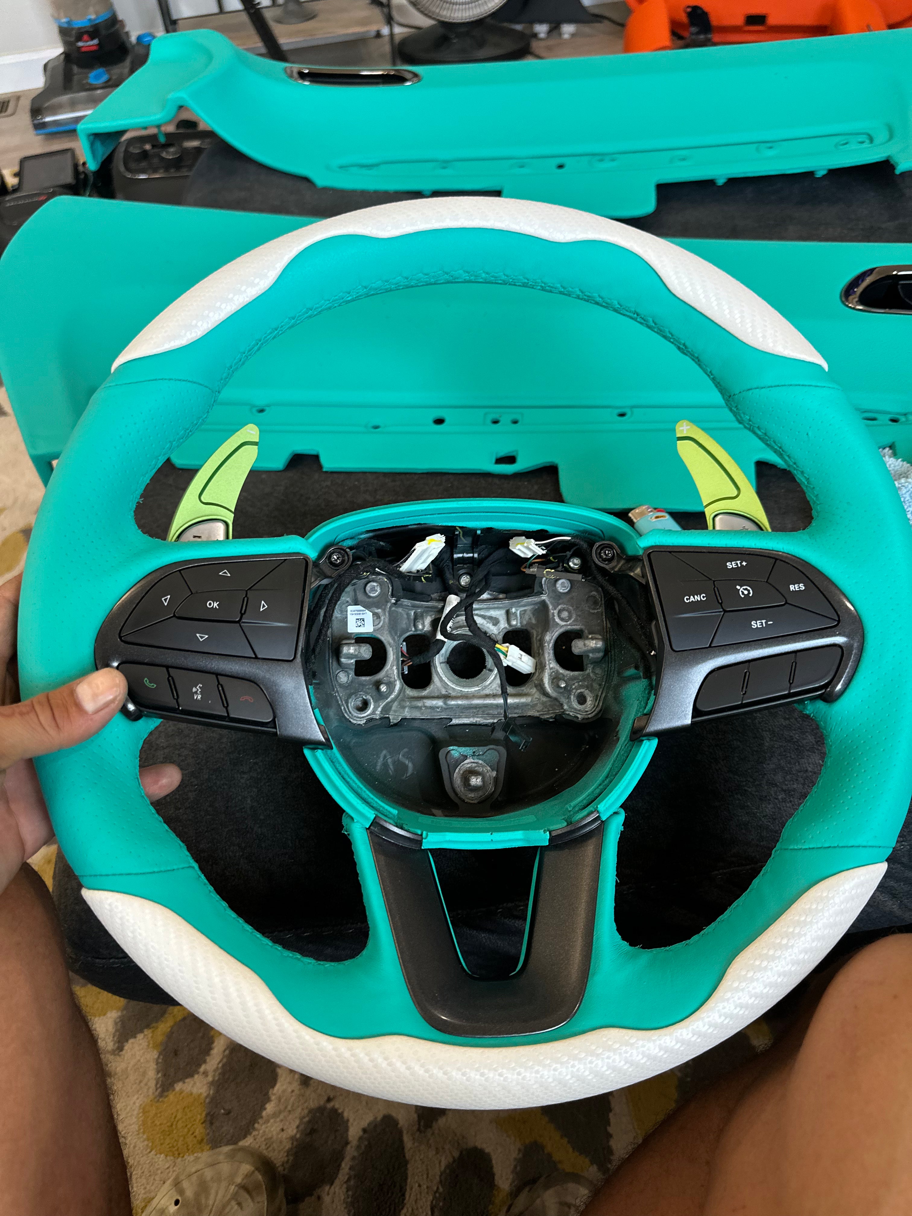 alt="Close-up of blue steering wheel after custom interior color change"